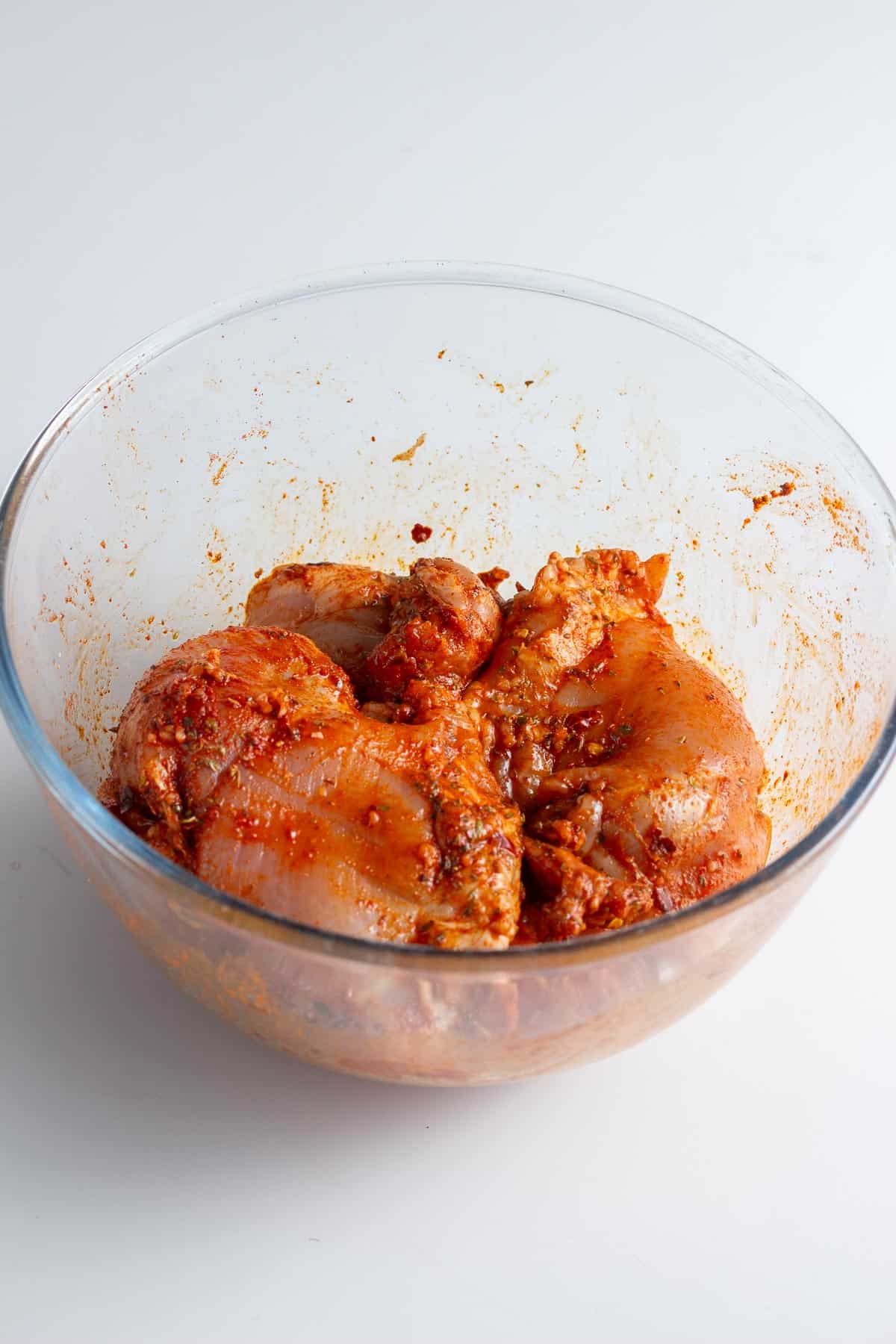 Glass bowl of chicken in marinade