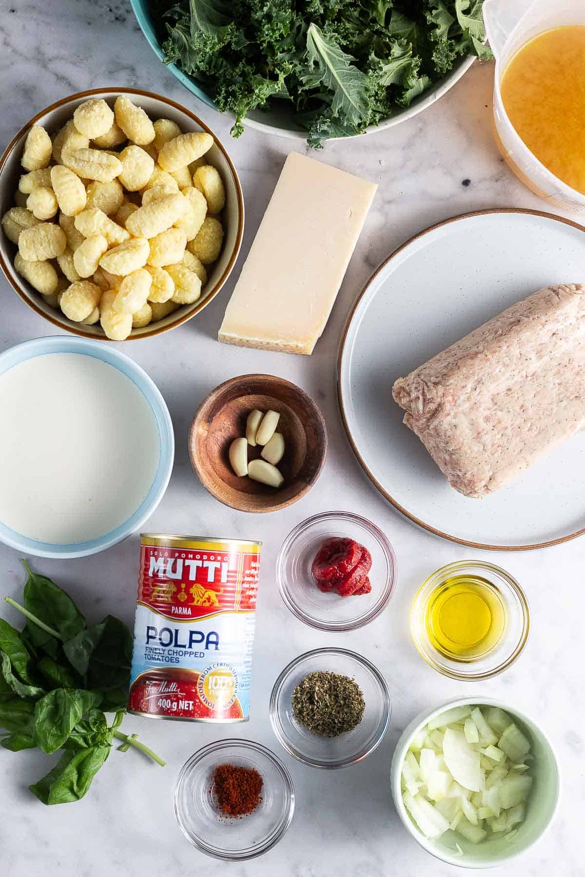 Ingredients for sausage gnocchi on a marble surface