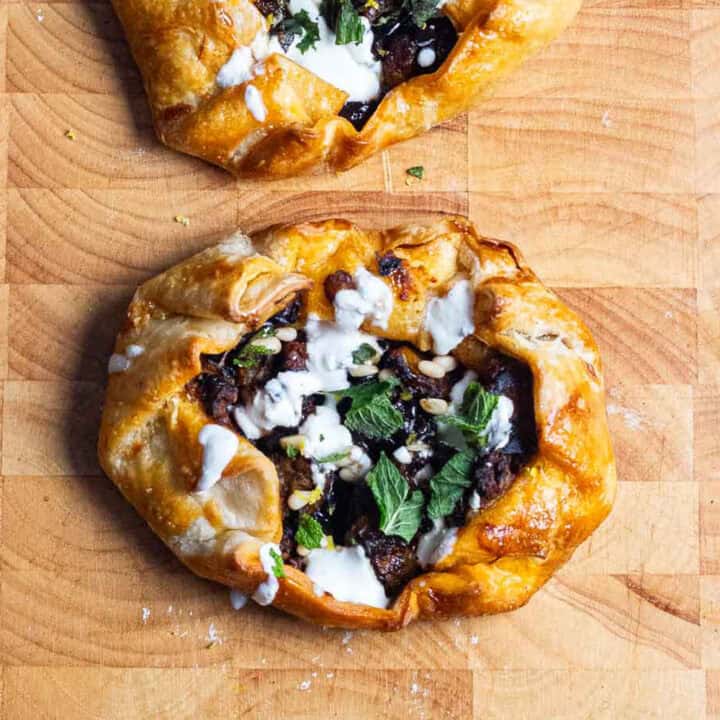 Wooden board with vegetable tart on it